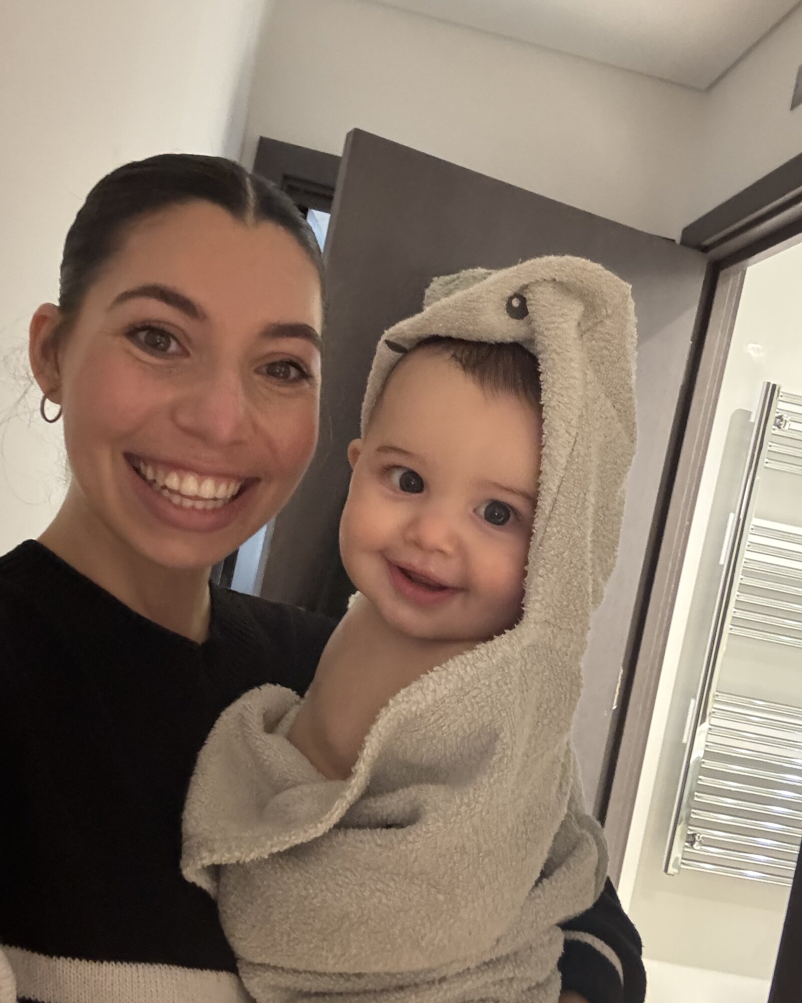 A mother holding her baby in a sunlit kitchen